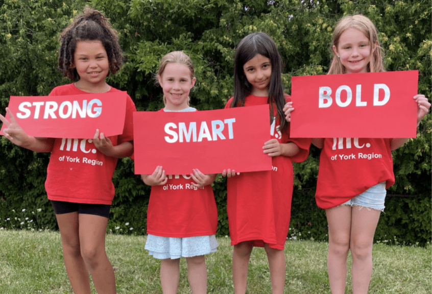 Girls Inc. girls holding STRONG SMART BOLD sign.